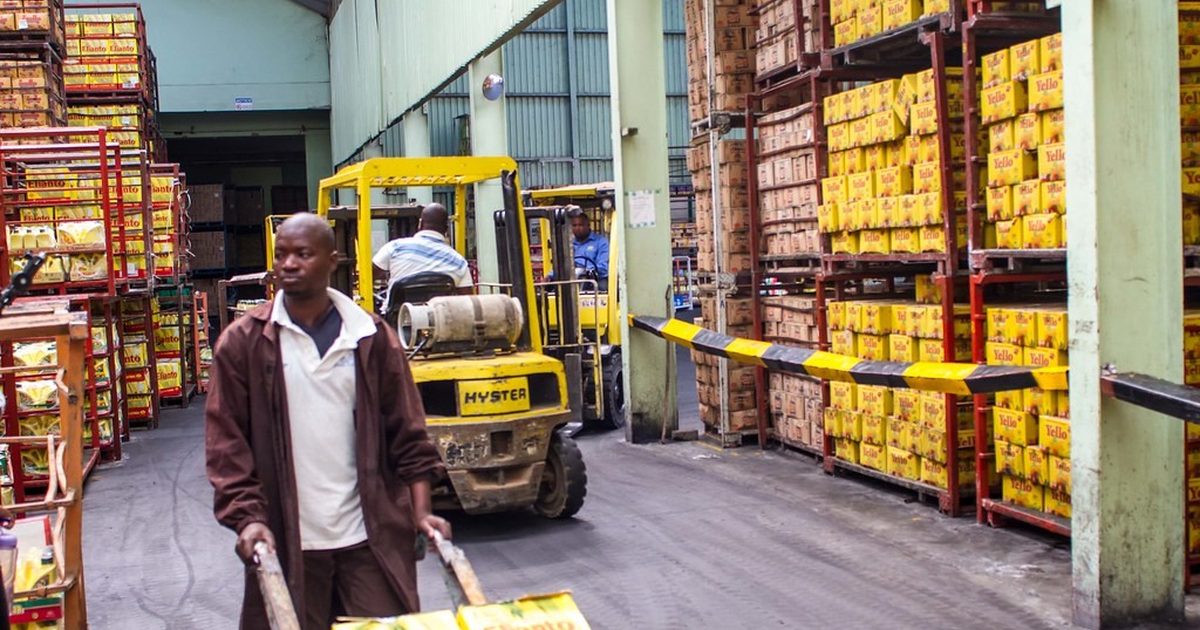 Warehouse worker and forklift moving stacked goods in a Kenyan warehouse
